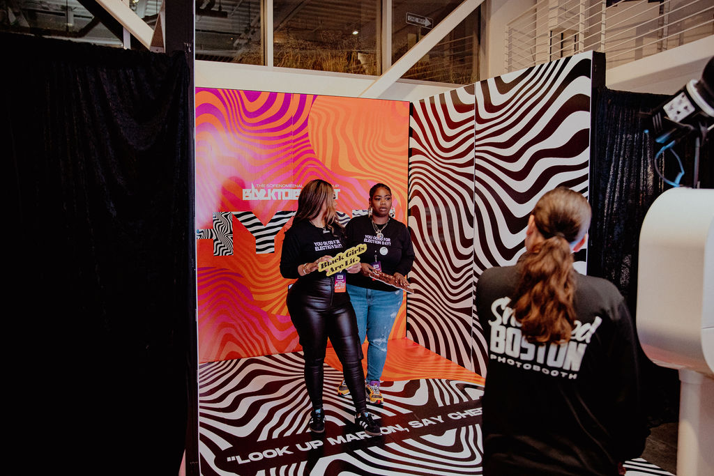 Snapped Boston attendant assisting guests at a zebra-print photo booth activation
